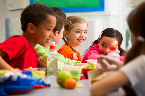 Young Students Enjoying Their Lunch At School Group of children having packed lunches school lunch child food lunch stock pictures, royalty-free photos & images