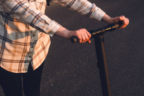 istock Girl holding her electric scooter in a sunset light 1808276409