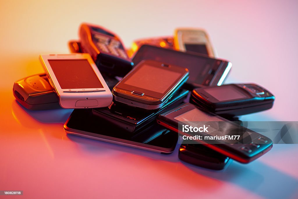 Old used cellphones pile Old used cellphones pile under mixed lights Old Stock Photo