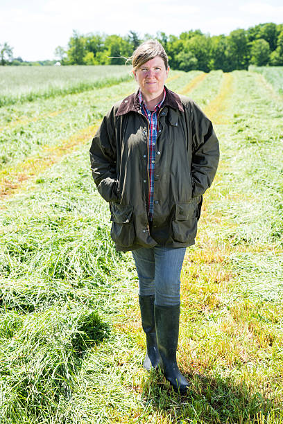 istock Female farmer in a freshly cut hayfield 180828525