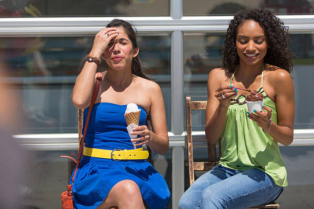 Ice Cream Headache "Women eating ice cream and getting a brain freeze, ice cream headache" lypsela2013 stock pictures, royalty-free photos & images