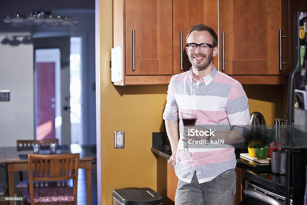 Człowiek posiadający napój w kuchni - Zbiór zdjęć royalty-free (30-34 lata)