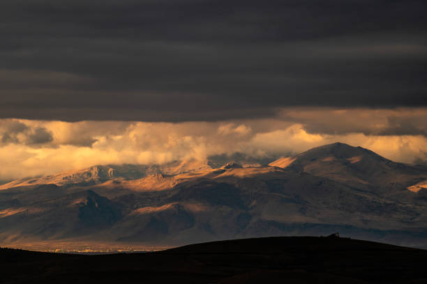View of Mount Hasan in the clouds in Aksaray province. It was shot with a full frame camera at sunset and under a cloudy sky. There is snow on the top of the mountain.