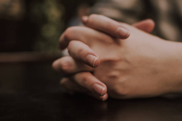 istock Girl's folded hands on a table in a cafe 1808293349