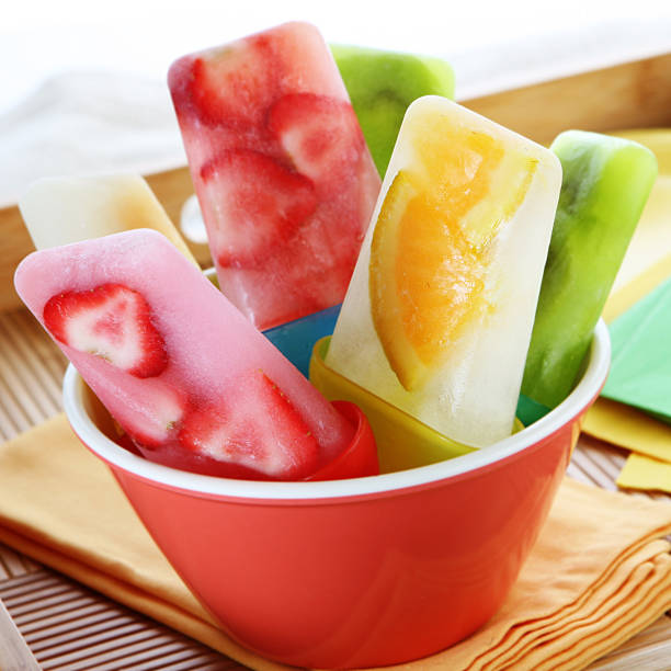 A red bowl of Popsicles made from fresh fruit