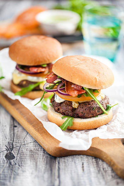 Homemade hamburgers served on a wooden paddle Homemade hamburgers veggie burger stock pictures, royalty-free photos & images