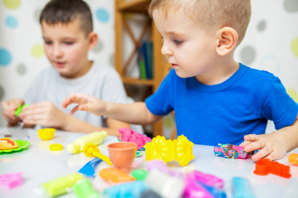 istock Children enthusiastically play with plasticine, play dough on white table 1808330667