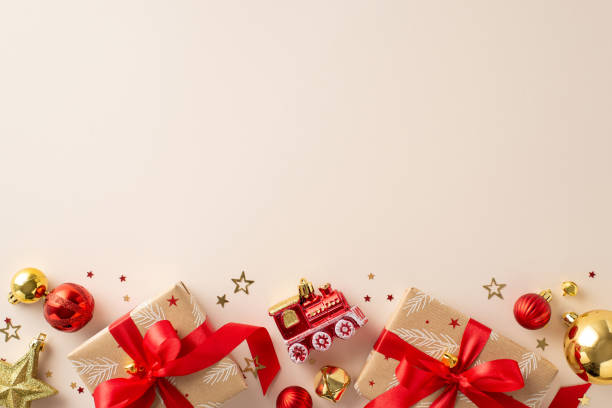 istock Festive vibes abound! Top view of rustic gift boxes, red and gold ornaments, train-themed tree decoration, jingle bells, and shiny confetti on a soft pastel backdrop. Perfect for New Year preparations 1808334388