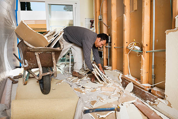 Construction Worker Cleans Up Drywall Demolition stock photo