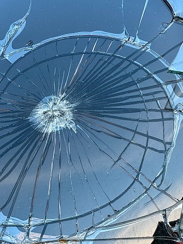 Broken glass close-up. Bullet hole in double glazed window. Window with cracked glass.