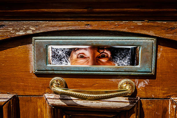 istock Woman's eyes peering out from letterbox 180835226