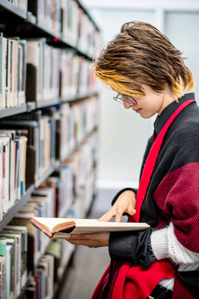 identidad moderna: adolescente no conforme con el género explora la biblioteca - university of manitoba fotografías e imágenes de stock