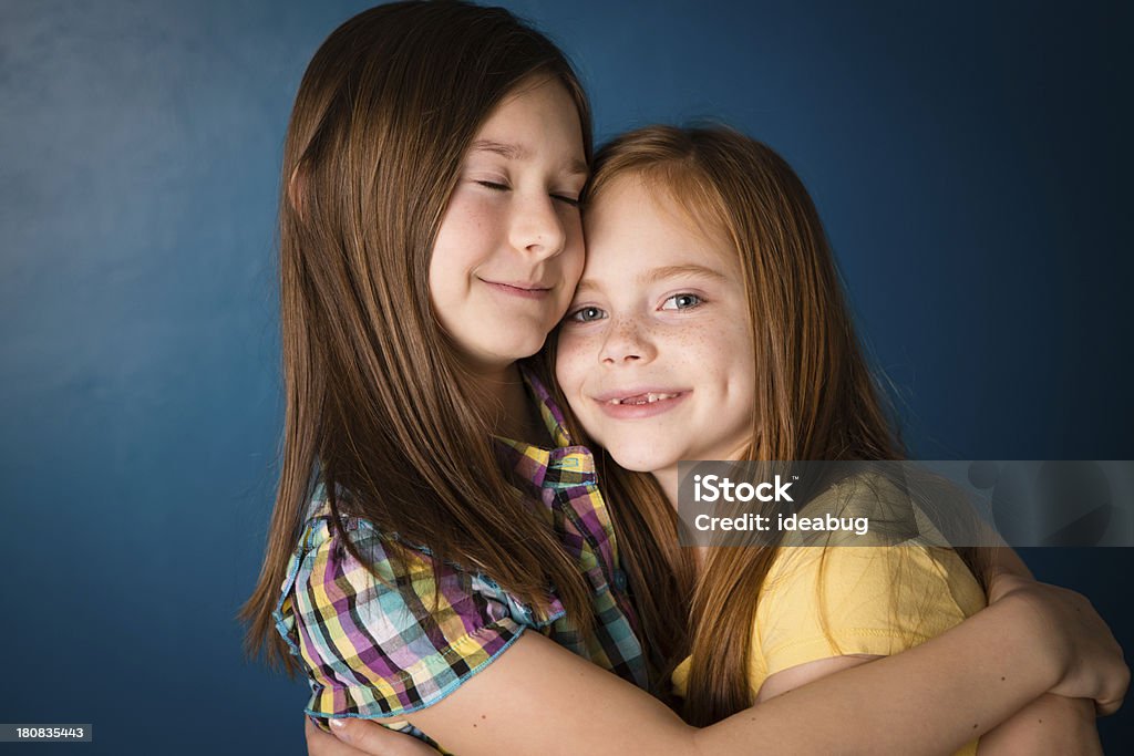 Due sorelle dare loro un caldo abbraccio - Foto stock royalty-free di 6-7 anni