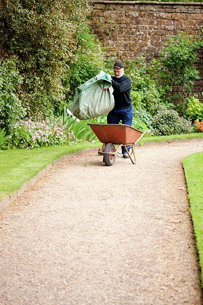 giardiniere raccolta di rifiuti verdi - mansion uk gravel summer foto e immagini stock