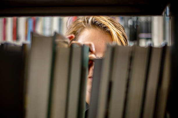 literary wonderland: teen's radiant expression amidst a world of books - university of manitoba imagens e fotografias de stock