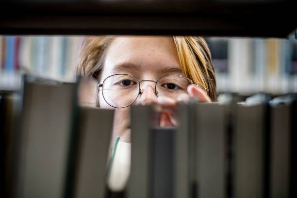 paese delle meraviglie letterarie: l'espressione radiosa di un adolescente in mezzo a un mondo di libri - canada manitoba university winnipeg foto e immagini stock