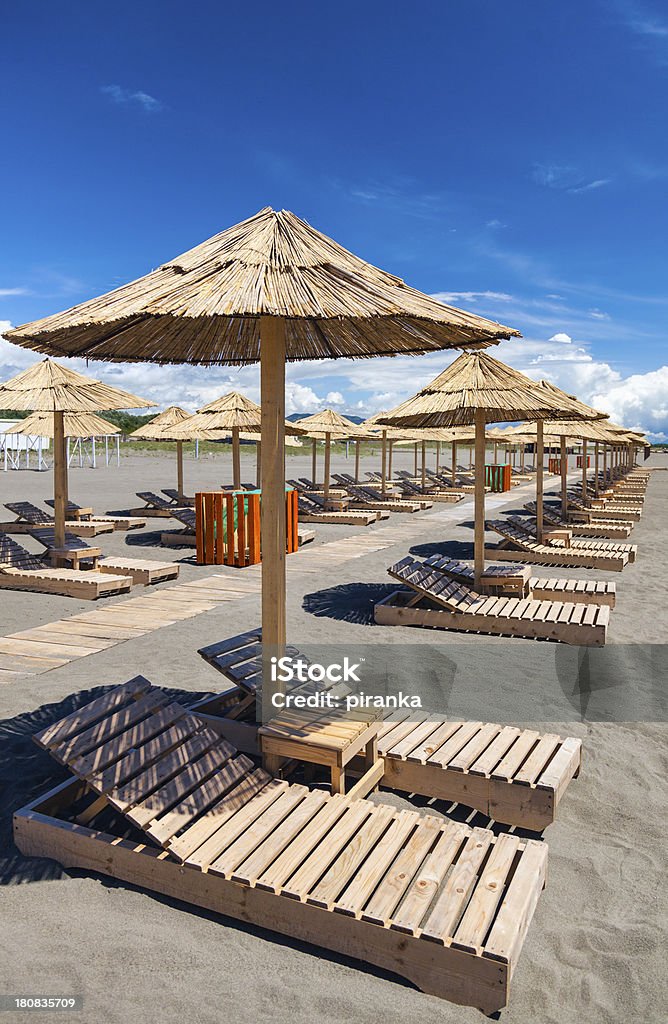 Stühle und Sonnenschirme am Sandstrand - Lizenzfrei Blau Stock-Foto