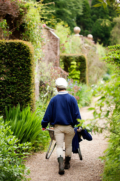 giardiniere con carriola - mansion uk gravel summer foto e immagini stock