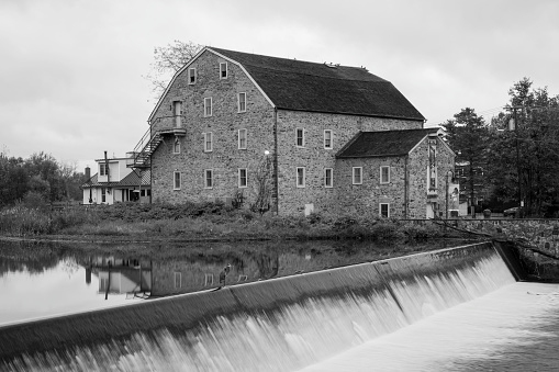 Clinton, USA - October 29, 2023. The Hunterdon Art Museum (historic stone mill) and its reflection  in Raritan River , Clinton, New Jersey, USA