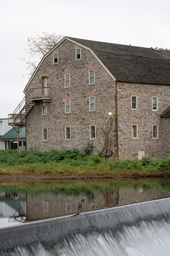 Clinton, USA - October 29, 2023. The Hunterdon Art Museum (historic stone mill) and its reflection  in Raritan River , Clinton, New Jersey, USA