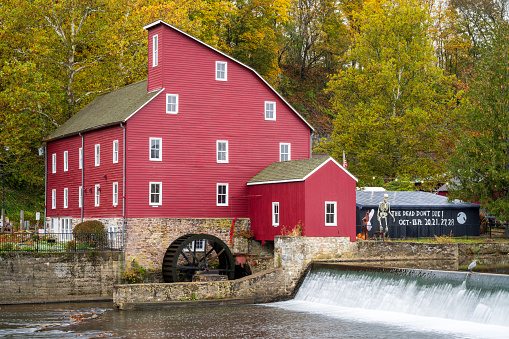 Clinton, USA - October 29, 2023. The Red Mill Museum and waterfalls at Raritan River, Clinton, New Jersey, USA