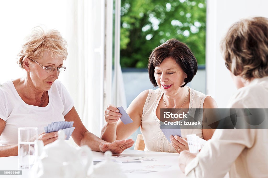 Cards game Three mature women playing cards together. Playing Card Stock Photo