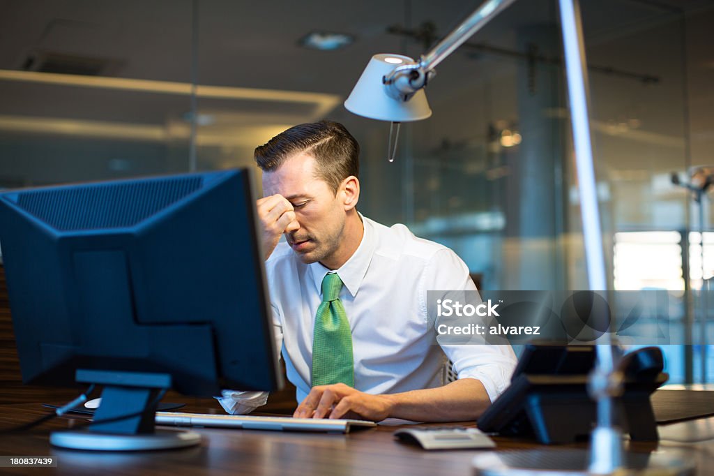Business man overwhelmed with work Business man overwhelmed working at nighthttp://bit.ly/1baBzlj Adult Stock Photo