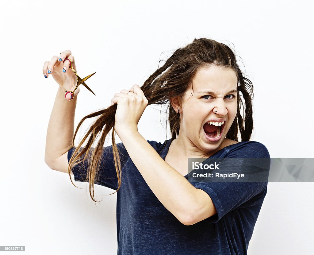 That's it! I'm cutting these dreadlocks off now! "This pretty young brunette woman shouts angrily as she loses patience with her tangled, dreadlocked hair and begins to cut the whole lot off." Cutting Hair Stock Photo