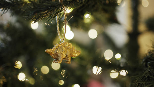 Toy dinosaur ornament hanging on a Christmas tree branch