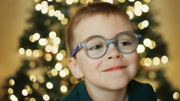 istock Smiling little boy sitting in front of a Christmas tree 1808378175
