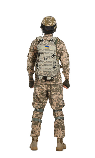 Soldier in Ukrainian military uniform with tactical goggles and backpack on white background, back view