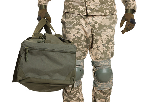 Ukrainian soldier in military uniform with army bag on white background, closeup