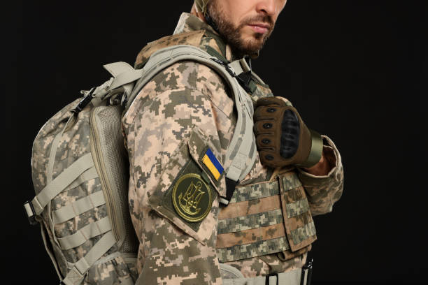 istock Soldier in Ukrainian military uniform with backpack on black background, closeup 1808383033