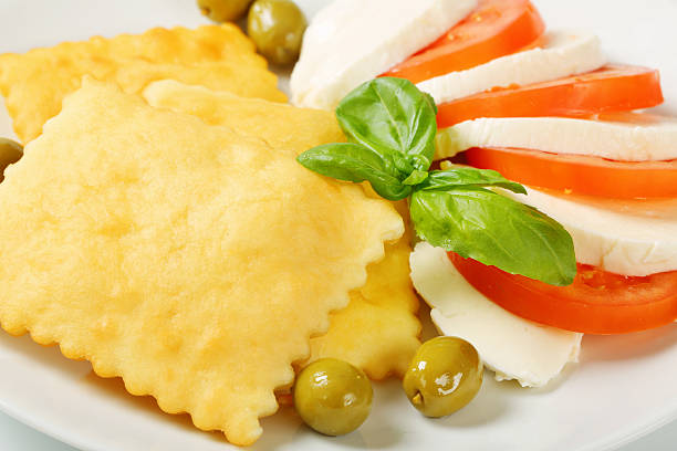 caprese-salat und gebratener teig zigaretten - gnocco fritto stock-fotos und bilder