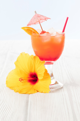 Tequila Sunrise cocktail and Hibiscus flowers. Selective focus.