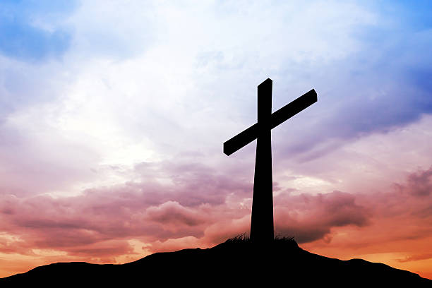 istock cross silhouette and the clouds at sunset 180838643