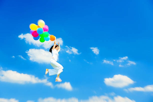 woman flying with colorful balloons