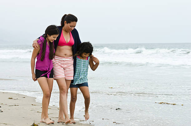 istock Mother and Daughters Walking On The Beach 180838937