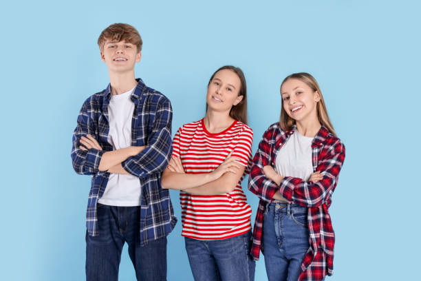 istock Group of happy teenagers on light blue background 1808389973