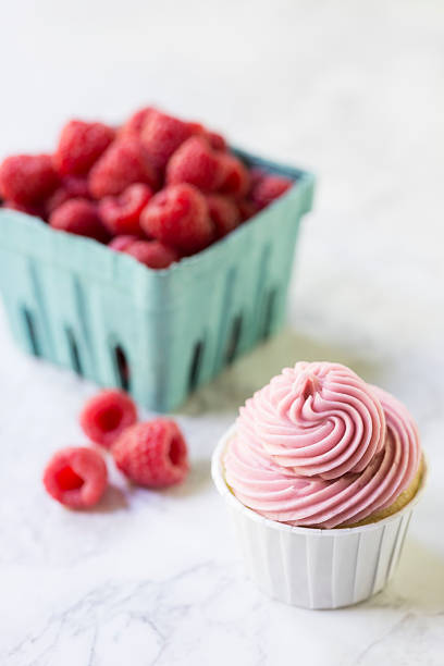istock Raspberry Filled Cupcake with a Basket of Berries 180839122