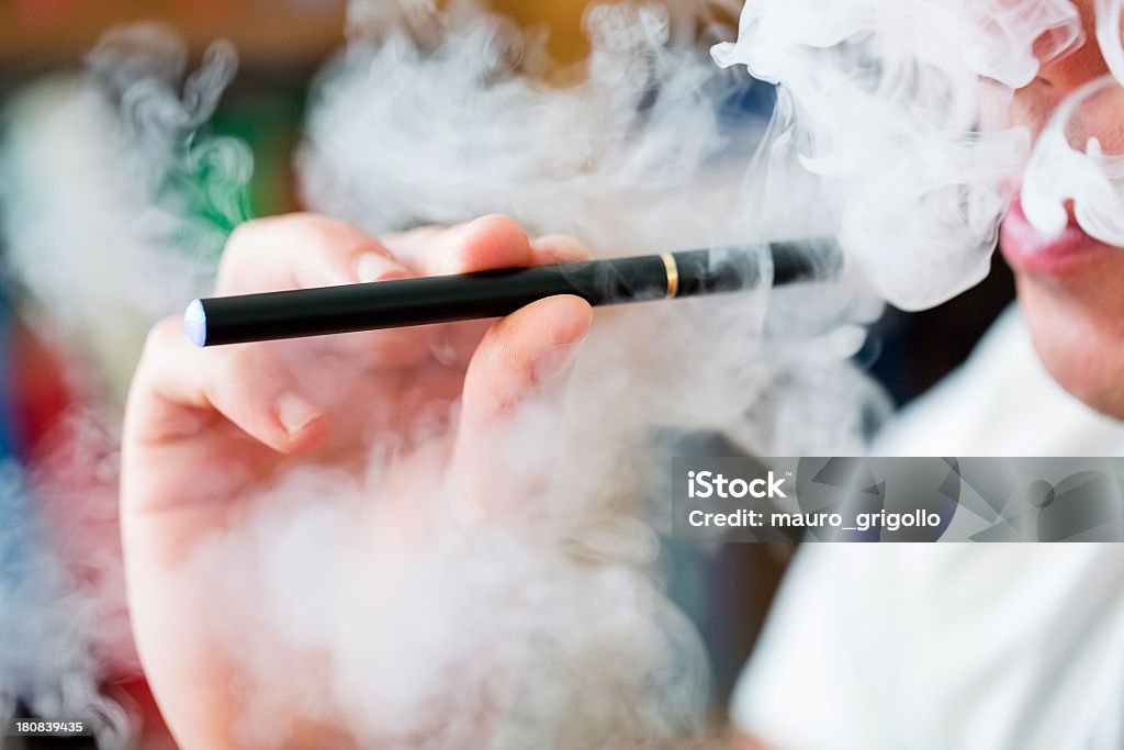 Smoking E-Cigarette Man smoking E-Cigarette indoor. Electronic Cigarette Stock Photo