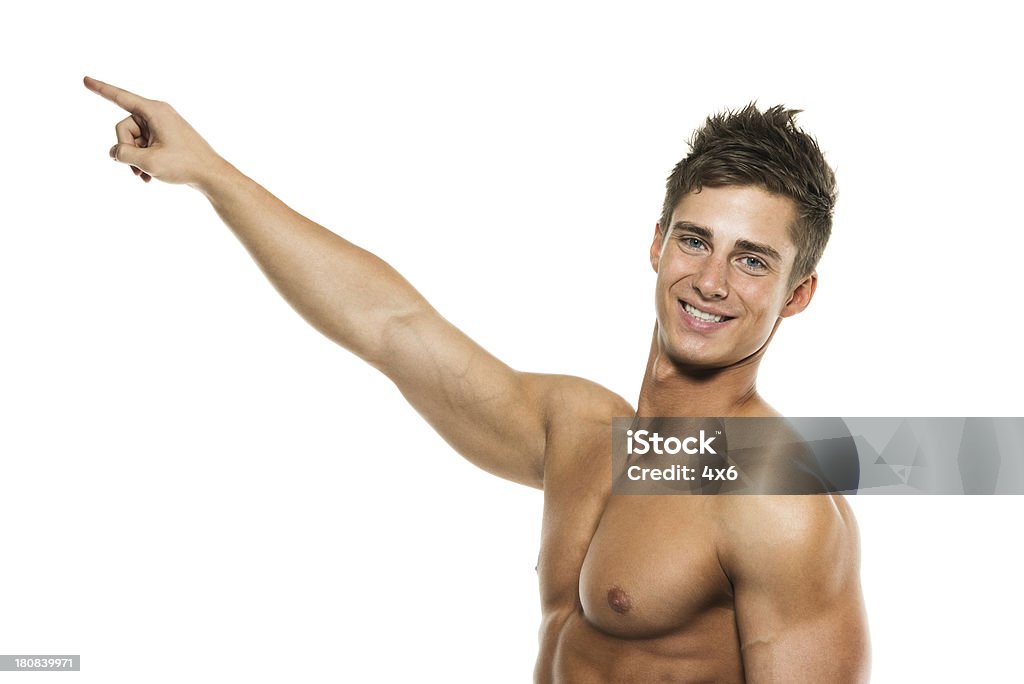 Felice uomo muscolare che indica - Foto stock royalty-free di A petto nudo