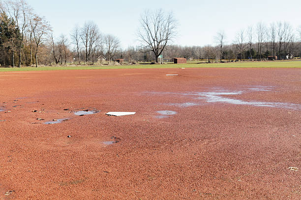 durchnässte frühling baseball diamond - baseball dirt softball baseball diamond stock-fotos und bilder