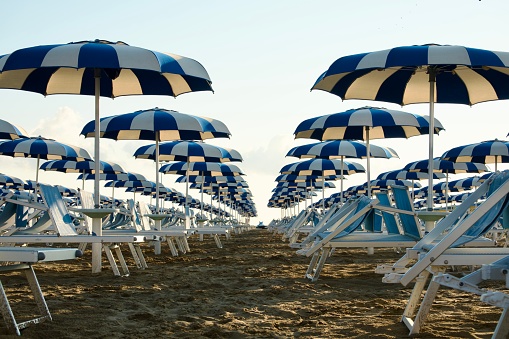 Still life shot of two deck chairs under an umbrella on the beach