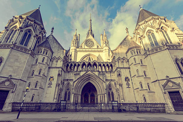 The Royal Courts of Justice with blue sky and clouds View of the main facade of The Royal Courts of Justice in London in the afternoon. royal courts of justice stock pictures, royalty-free photos & images