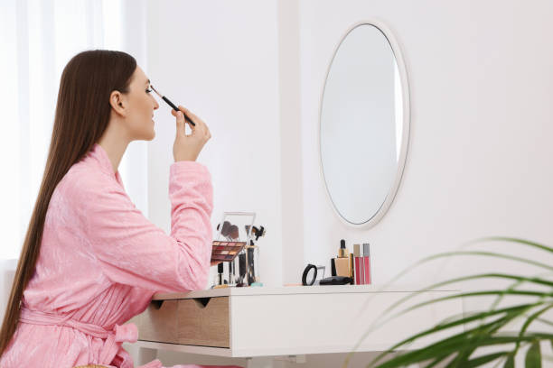 istock Woman applying makeup with brush at dressing table indoors. Space for text 1808421866