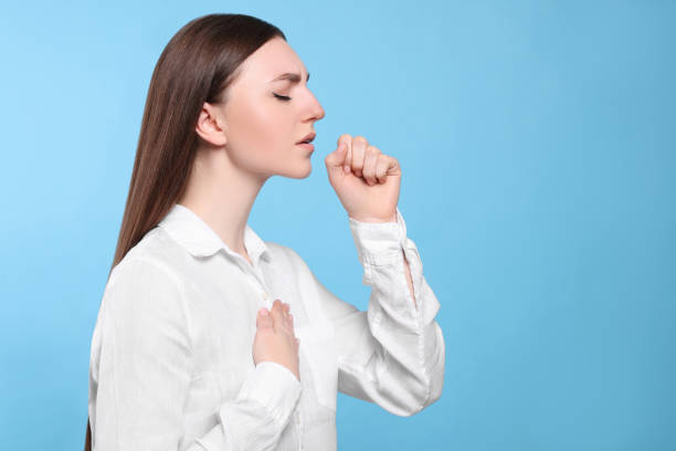 istock Young woman coughing on light blue background, space for text. Sore throat 1808421885