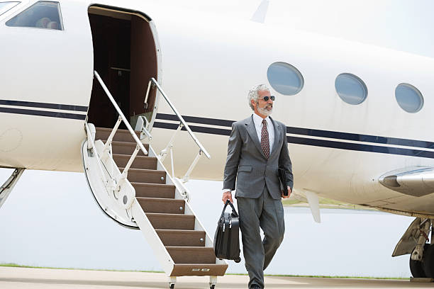 istock Mature businessman exiting private jet after flight 180842283