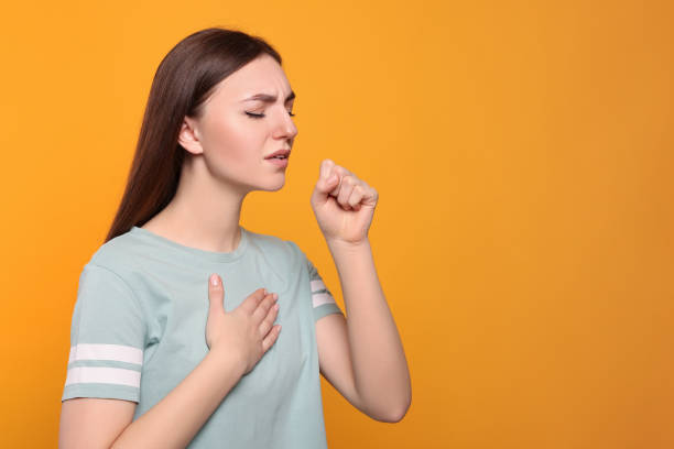 istock Young woman coughing on orange background, space for text. Sore throat 1808424559