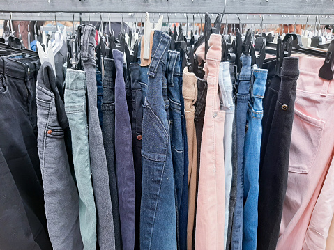 Group of jeans hanging on coat rack